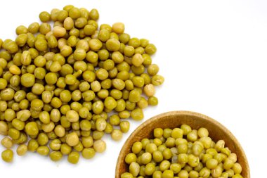 Beyaz zemin üzerinde konserve yeşil bezelyeler.