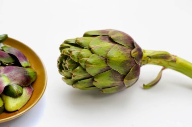 Beyaz arkaplanda mor enginar.