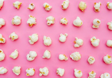 Pembe arka planda patlamış mısır.