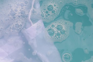 Toz deterjana batırılmış beyaz bez deterjan çözeltisi, bez. Çamaşır konsepti