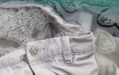 Pantolonlar toz deterjana batırılmış su çözeltisi, bez. Çamaşır konsepti