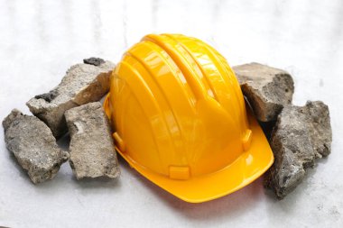 Kırık beton bloklu sarı inşaat işçisi kaskı