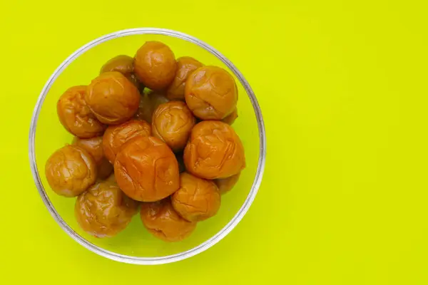 stock image Pickled plums on green background.