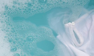 Toz deterjana batırılmış beyaz bez deterjan çözeltisi, bez. Çamaşır konsepti