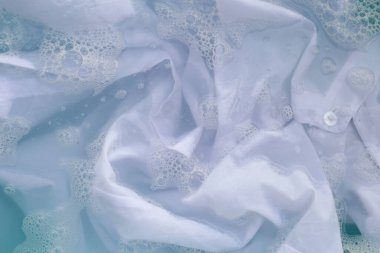 Toz deterjana batırılmış beyaz bez deterjan çözeltisi, bez. Çamaşır konsepti