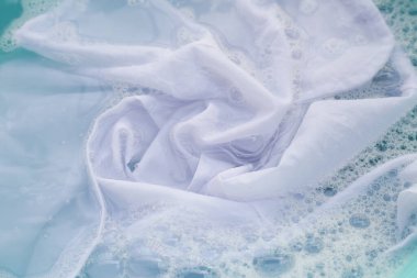 Toz deterjana batırılmış beyaz bez deterjan çözeltisi, bez. Çamaşır konsepti