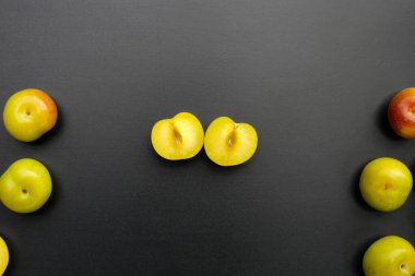 Koyu arkaplanda taze yeşil erik meyvesi.