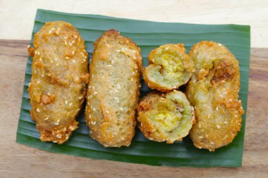 Deep-fried banana rolls with unripe rice grain clipart