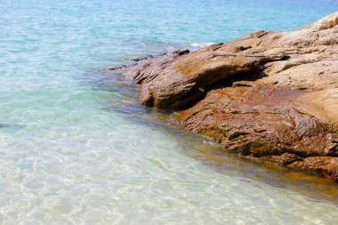 Mavi deniz, kayalarla kaplı su dokusu.