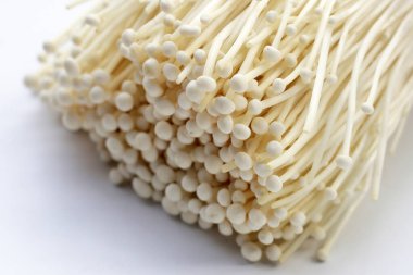 Fresh Enoki mushrooms on white background clipart