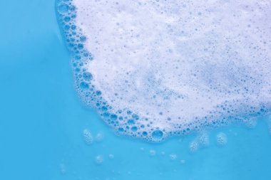 Deterjan köpüklü su. Mavi arkaplan, sabun suyu