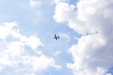 Mavi gökyüzünde bulutlu küçük bir uçak