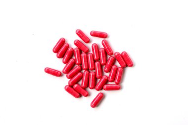 Beyaz arka planda kırmızı Astaxanthin ek kapsülleri.