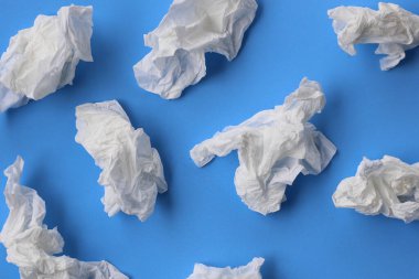 Mavi bir yüzeye dağılmış buruşuk dokular kullanılmış..