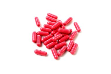 Beyaz arka planda kırmızı Astaxanthin ek kapsülleri.