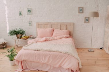 Yatak odası tasarımı, pembe çarşaf ve örgü örtüsü.