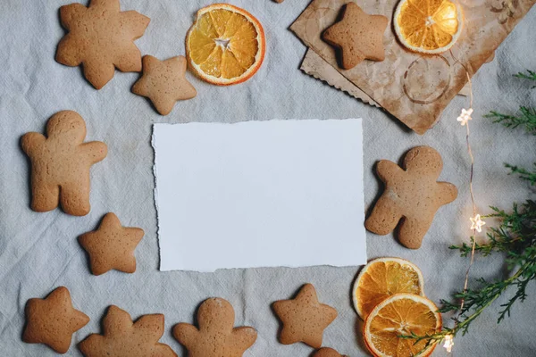 ジンジャーブレッド ホリデースイーツ クリスマスクッキー ホワイトペーパーモックアップの背景にグリーティングカードモックアップ — ストック写真
