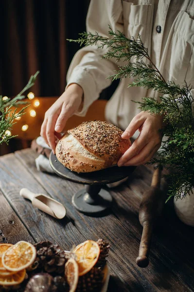 Frauenhände Halten Selbstgebackenes Brot Mit Körnern Auf Dunklem Hintergrund — Stockfoto