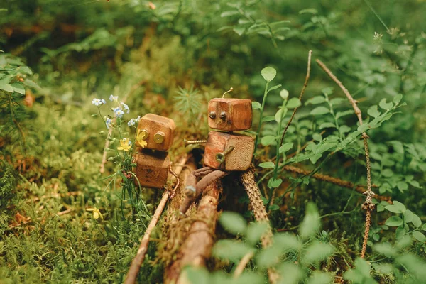 Wooden vintage handmade robot toy, eco friendly toy, forest background