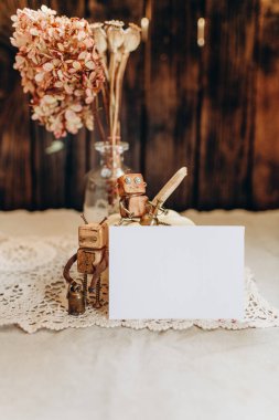 Davetiye modeli beyaz bir balkabağının arka planına ve eski tarz kurumuş çiçeklere ve klasik bir robot oyuncağına karşı.