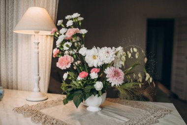 Sonbahar şenlikli düğün buketi açık beyaz renkli vazoda, çiçek desenli.