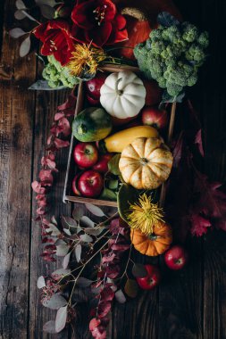 Kırsal tarzda sonbahar tatili dekoru. Arka planda çiçekler ve sebzelerle süslenmiş.