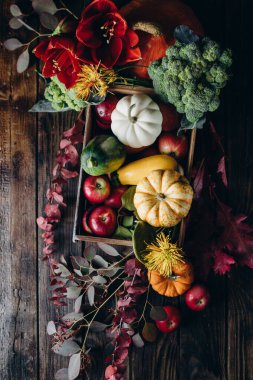 Kırsal tarzda sonbahar tatili dekoru. Arka planda çiçekler ve sebzelerle süslenmiş.