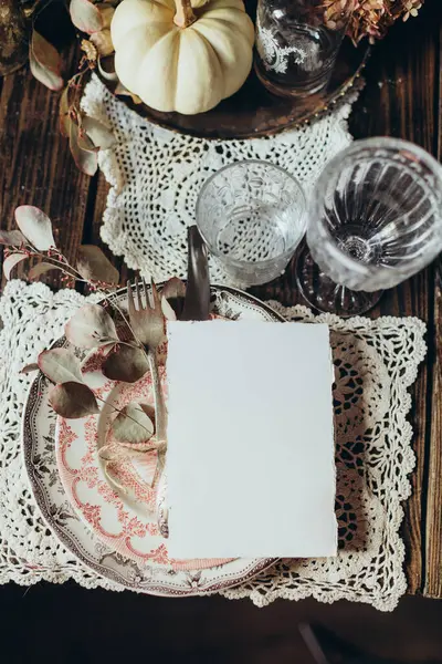 White sheet of paper on a set table, card mockup on a table decorated in vintage style