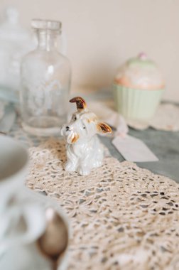 Çay fincanı ve çay tabağı bir masada çay saatiyle birlikte.