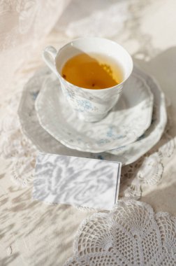 Bir fincan çay fincanının arka planına karşı bir fincan çay daveti.