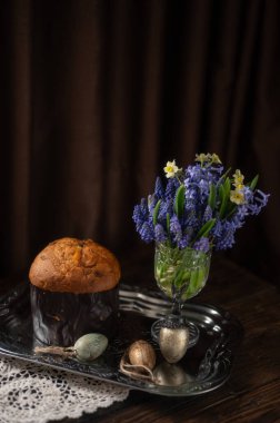 Geleneksel Paskalya Pastası ve Altın Yapraklı Beyaz Yumurtalar Bahar Çiçekleri ile Kırsal Masada