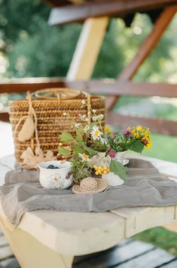 Kırsal bir masa üzerinde narin çiçek aranjmanı ve böğürtlen