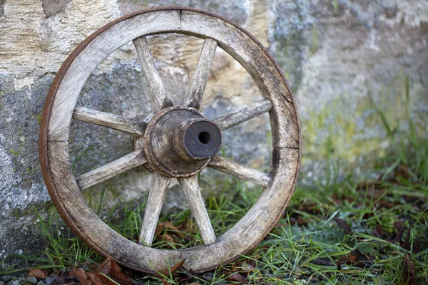 石の壁にもたれるヴィンテージ木製の車輪 — ストック写真
