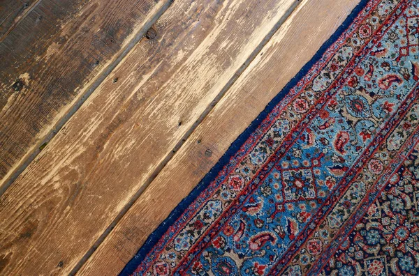 Old wooden floor with old handmade wooven rug in a farm house