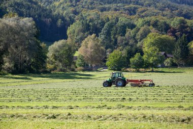 Tarım tarlasında saman ayıcıklı traktör