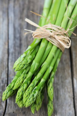 Eski ahşap bir masada bir sürü taze kuşkonmaz.