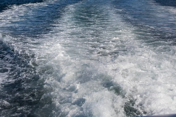 Background boat ocean wake surface behind fast moving boat