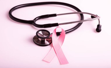 Pembe kurdele ve steteskop. Göğüs kanseri farkındalığının sembolü. Sağlık ve tıp konsepti. Önleyici önlemler. Kadın sağlığı