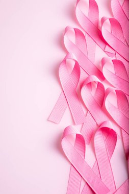 Pembe kurdele pembe arka planda izole edilmiş. Göğüs kanseri farkındalığının sembolü. Sağlık ve tıp konsepti. Önleyici önlemler. Kadın sağlığı