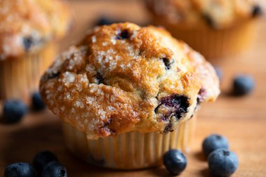 Tahta üzerinde yabanmersini olan kekler (muffinler). Sabah çayı ya da kahvaltı için lezzetli bir yaz tatlısı.