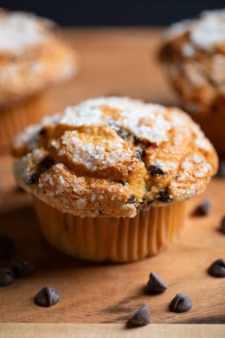 Tahta üzerinde çikolata parçacıkları olan kekler (kekler). Sabah çayı ya da kahvaltı için lezzetli bir yaz tatlısı.