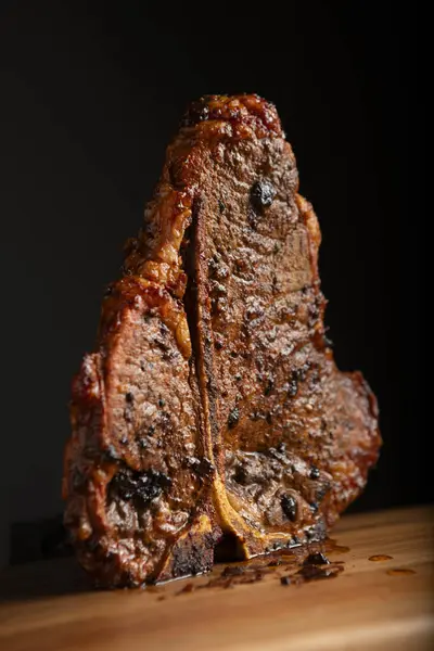 Yüksek Kaliteli Sulu Sanatsal T-Kemik Bifteği Tahta kesim tahtasının üzerinde duruyor