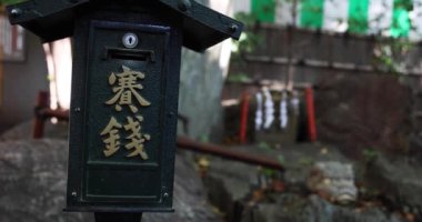 A traditional landscape at Tanashi Shrine in Tokyo. Nishitokyo district Tanashi Tokyo Japan 10.20.2022 Most shrines in Japan have a box where you can offer money when you pray. Translation on box text