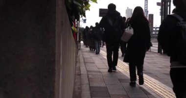 A slow motion of walking people on the street in the city. High quality 4k footage. Chuo district Tokyo Japan 01.18.2023 Here is an electric quarter in Tokyo. It is center of the city in Tokyo. 