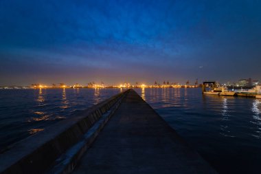 Tokyo 'daki konteynır limanının yakınındaki karanlık bir şehir manzarası. Yüksek kalite fotoğraf. Koutou Bölgesi Aomi Tokyo Japonya 01.13.2023: Tokyo 'da bir konteyner limanıdır..