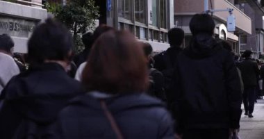 Şehir caddesinde yürüyen insanlardan oluşan bir kalabalık. Yüksek kalite 4K görüntü. Chuo bölgesi Tokyo 02.02.2023 Tokyo 'da bir elektrik çeyreği. Tokyo 'nun merkezindedir.. 