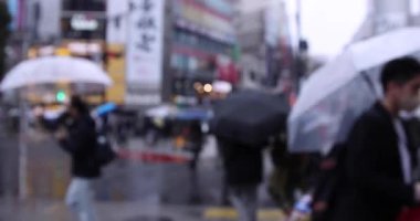 ShiBUYA 'da yağmurlu bir günde yürüyen insanlar. Yüksek kalite 4K görüntü. Shibuya bölgesi Tokyo 02.10.2023 Tokyo 'nun merkezidir.. 