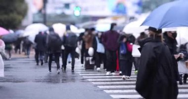 ShiBUYA 'da yürüyen insanlar yağmurlu bir günde geçiyorlar. Yüksek kalite 4K görüntü. Shibuya bölgesi Tokyo 02.10.2023 Tokyo 'nun merkezidir.. 