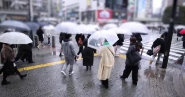 ShiBUYA 'da yürüyen insanlar yağmurlu bir günde geçiyorlar. Yüksek kalite 4K görüntü. Shibuya bölgesi Tokyo 02.10.2023 Tokyo 'nun merkezidir.. 