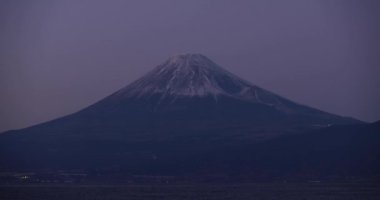 Kışın mavi gökyüzünün arkasında Fuji Dağı 'nın alacakaranlığı. Yüksek kalite 4K görüntü. Numazu bölgesi Heda Shizuoka Japonya 01.25.2023